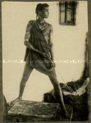 Massai Amri mit Pfeil und Bogen in Beobachtungshaltung