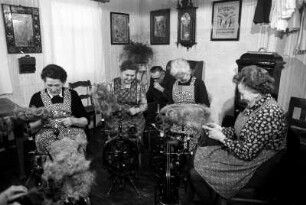 Frauen beim Flachsspinnen in Wohnstube