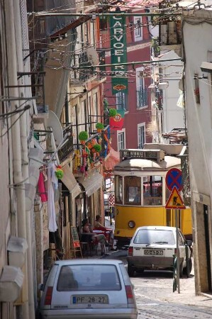 Lissabon, enge Altstadtgasse im bergigen Stadtviertel Alfama, mit Straßenbahnverkehr