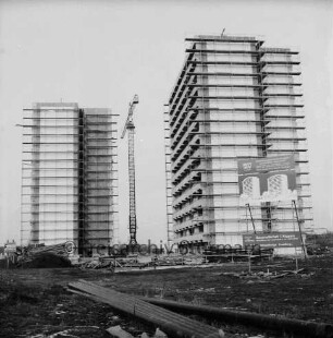 Poggenseer Weg: Hochhäuser: zwei Rohbauten mit Gerüst, dazwischen Baukran: vorn Baumaterial, rechts Bauschild: Winter: 19. Januar 1973