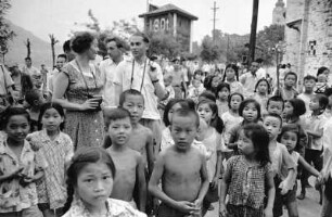 Europäische Besucher inmitten chinesischer Kinder auf einer Straße : Whansien (China). Europäische Besucher inmitten chinesischer Kinder auf einer Straße