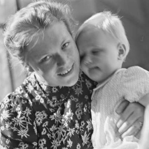 Kleinkind sitzt auf dem Schoß der Mutter
