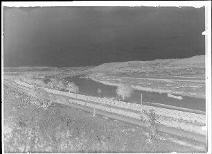 Staustufe Himmelstadt. Weitläufige Ansicht des Maines und umliegenden Geländes. Im Vordergrund ist ein Teil der Bahnstrecke erkennbar, im Hintergrund Himmelstadt mit Brücke über den Main. Baumaßnahmen.