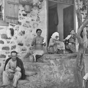 Griechenland. Insel Limnos. Vor dem Anwesen wird Baumwolle verabeitet und gesponnen.