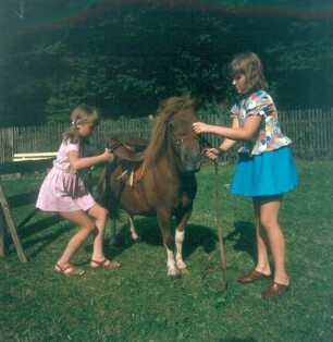 Zwei Mädchen beim Satteln eines Ponys