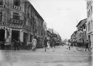 Singapur. Blick in eine Geschäftsstraße mit Passanten, Rikschas und Fuhrwerk