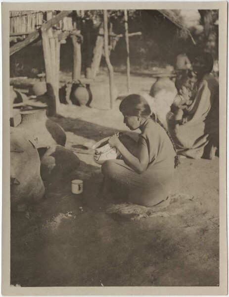 Chané painting a clay pot