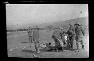 Übungsgelände II bei Mouzon (Dep. Ardennes, Frankreich): 5 Soldaten mit Stahlhelm auf einem Feld neben einem auf dem Boden stehenden [Minenwerfer]