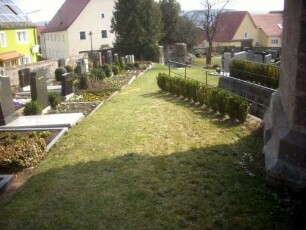 Kirchhof im Osten mit Kirchhofmauer im Verlauf (Wehrgang im 19 Jh abgetragen) sowie Rest des einstigen Torbaus (Kammertor mit Zangenmauern) in Übersicht