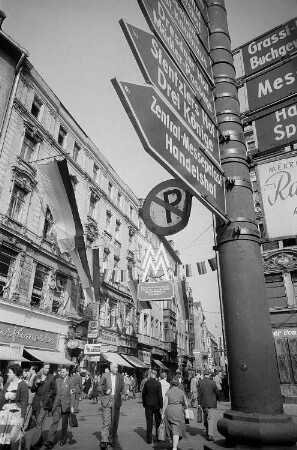 Messewegweiser und Passanten während der Leipziger Herbstmesse 1955