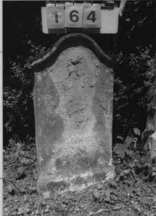 Grabstein 164 (Index: 99789862) Material: Sandstein Zustand: sehr stark verwittert mit fast vollständigem Textverlust Maße HxBxT: 82x43x15 cm Besonderheit: Kindergrab: Grabstein 164