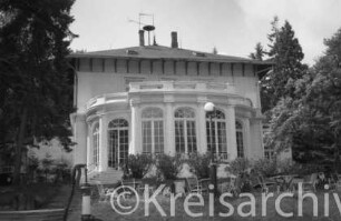 Parkhotel Manhagen: seitliche Gartenfront mit Veranda: Gartentreppe, Gartenstühle