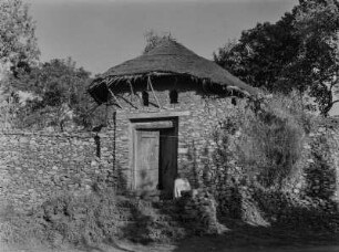 Bruchsteinhaus : Ein Mann sitzt vor dem Eingang eines Bruchsteinhauses in der Nähe von Gondar