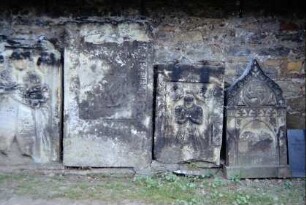 alte Grabsteine an der Kirchenwand