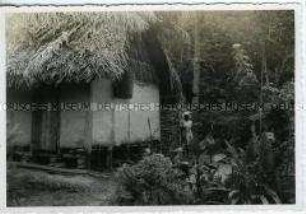 Einheimische neben ihrem strohgedeckten Haus, Trinidad