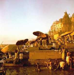 Ghats mit Badestellen im Lichte des Sonnenaufgangs. Pilger bei rituellen Handlungen