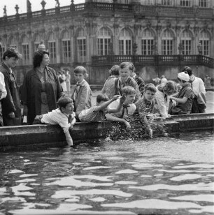 Dresden-Altstadt. Lehrerin (oder Pionierleiterin) mit einer Gruppe Junger Pioniere am Rand eines Brunnenbeckens im Zwingerhof