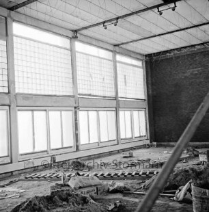 Dörfergemeinschaftsschule: Neubau: Innenraum der Turnhalle im Rohbau: vorn Baumaterial
