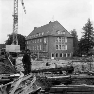 Woldenhorn-Schule: Sonderschule des Kreises Stormarn für geistig behinderte Kinder: Ecke Reeshoop / Schulstraße: Erweiterungsbau: in Bau: Baugrube mit Verschalungen für Fundamente: Arbeiter, Bretter, Baustahl-Armierungen, Aushub: Baukran: hinten Altbau: Blick von Hans-Schadendorff-Stieg aus