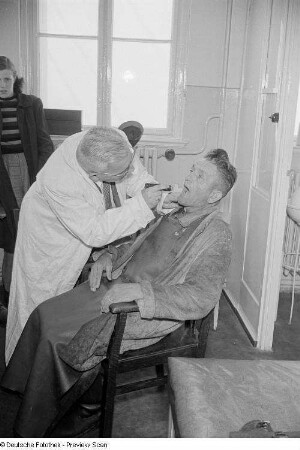 Zahnarzt untersucht einen Patienten