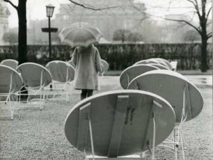 München. In einem Garten-Cafe im Englischen Garten trotzt ein Gast dem Regen. Man nutzt einfach einen Schirm