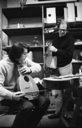 Köln. Mauricio Kagel und einer seiner Mitarbeiter, welcher ein altes Streichinstrument ausprobiert, im Archiv