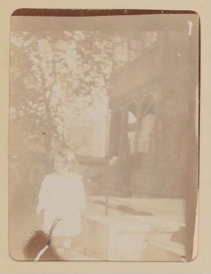Christiane von Hofmannsthal als Kleinkind vor einer Holzveranda