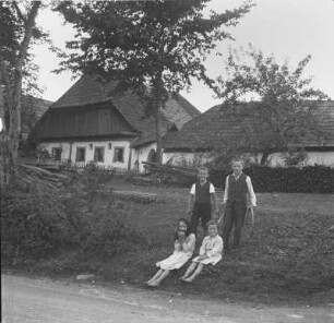 Bauernhof : Vier Kinder vor einem Gebäude eines Bauernhofs im Böhmerwald.