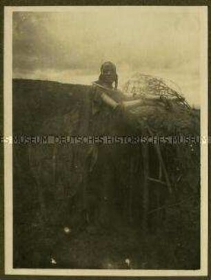Massai-Frau am Eingang einer Enkang-Hütte