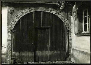 Haus 154. Tor 1599, Schlußstein Winzerzeichen. In den Bogenzwickeln 2 Fratzen