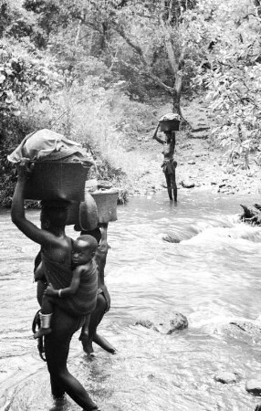 Frauen am Fluss : Frauen mit Körben auf dem Kopf überqueren einen Fluss