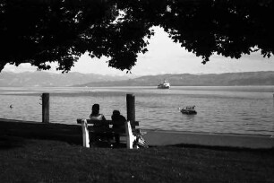 Langenargen: Blick auf See mit Schiff, Vordergrund Bank