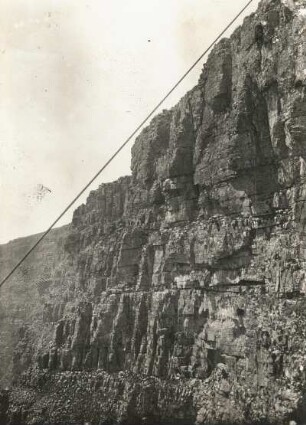 Südafrika. Kapstadt. Die terrassenförmigen Steilwände des 1000m hohen Tafelberges mit dem Seil der in 7 Minuten nach oben führenden Drahtseilbahn