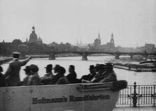Rundfahrtenbus auf der Albertbrücke mit Blickrichtung Carolabrücke, dahinter die Silouhette der Altstadt