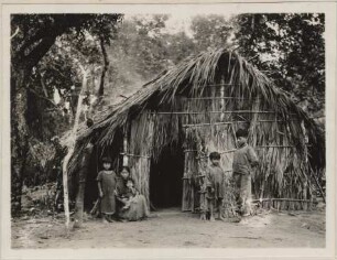 Bakairi-Indianer vor einer Hütte