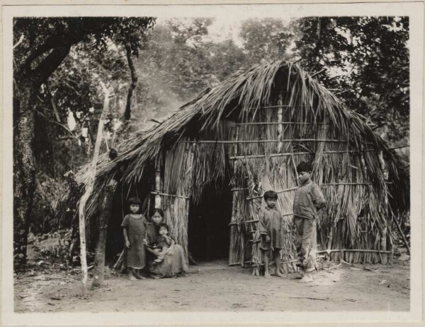 Bakairi-Indianer vor einer Hütte