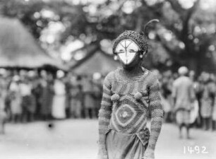 Maske, Kopf- und Körperbedeckung : Person mit Maske sowie gestrickter Kopf- und Körperbedeckung.