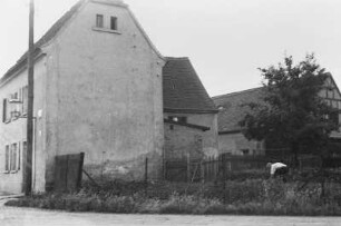 Mann in einem Garten : Ein Mann arbeitet in einem Garten vor einem großen Gebäude