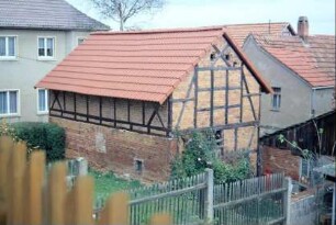 Blick auf eine Fachwerkscheune in einem Garten