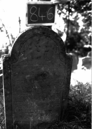 Grabstein 846 (Index: 100102931) Material: Sandstein Zustand: angewittert Maße HxBxT: 104x61x10 cm Beschreibung: Stele, eingezogener Rundbogenabschluss, Schriftfeld durch Rille abgeteilt, mit Konvexbogenabschluss: Grabstein 846