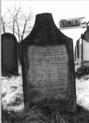 Grabstein 145 (Index: 100116318) Material: Sandstein Zustand: gut Maße HxBxT: 133x67x15 cm Beschreibung: Stele mit stark konkav eingezogenem Segmentbogenabschluß, eingetieftes Schriftfeld: Grabstein 145