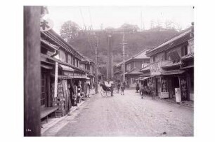 Blick zum 100-Stufen-Teehaus in Yokohama : Weltreisen. Japan. Yokohama. Straßenszene mit Rikschas in einer Ladenstraße. Blick zu den 100 Stufen des 100-Stufen-Teehauses auf dem Hügel