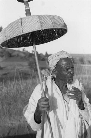 Mann der Oromo : Portrait eines Mannes der Oromo mit geknüpftem Sonnenschirm
