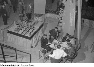 Besucher der Technischen messe 1953 an einem Tisch sitzend