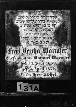 Grabstein 131 (Index: 100092975) Material: Granitplatte, Schriftplatte: Marmor Zustand: gut Maße HxBxT: 96x81x63 cm Beschreibung: schräg stehende, breite Platte mit aufgesetzter Schriftplatte Besonderheit: Zitat Hosea 14, 6: Grabstein 131A
