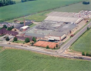 British American Tobacco (BAT): Luftbild des Gewerbegebietes am Beimoorweg: im Vordergrund Beimoorweg, im Hintergrund Bahnstrecke Hamburg-Lübeck