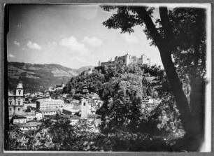 Salzburg, Festung Hohensalzburg : Salzburg. Teilansicht der Innenstadt mit dem südlichen der beiden Domtürme und der Erzabtei St. Peter. Blick vom Mönchsberg zur Festung von Nordwesten