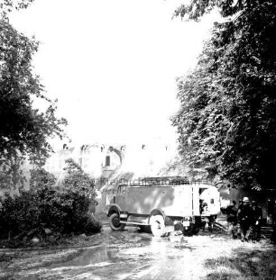 Kreiskinderheim Grande: Brand: im Vordergrund rechts Löschwagen der Feuerwehr mit Feuerwehrleuten: Löscharbeiten am brennenden Reetdach