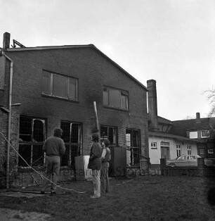 Brand: Bargfelder Straße: Warenlager des "Abholmarkts Elmenhorst" [ehemaliges Meiereigebäude]: Inhaber und Mitarbeiter vor Brandruine