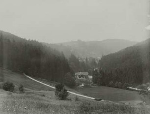 Ortsteilansicht. Blick über ein Landhaus mit Gartenanlage talabwärts